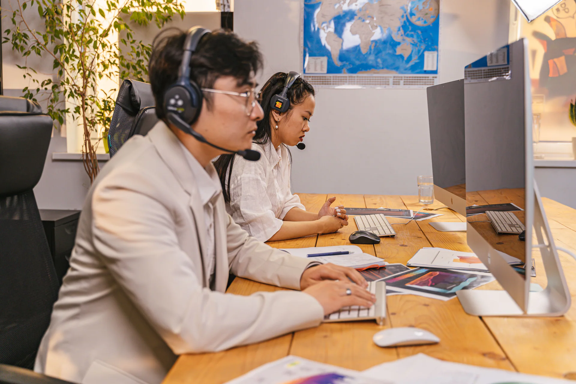 Two support agents working at a dispatch desk with headsets