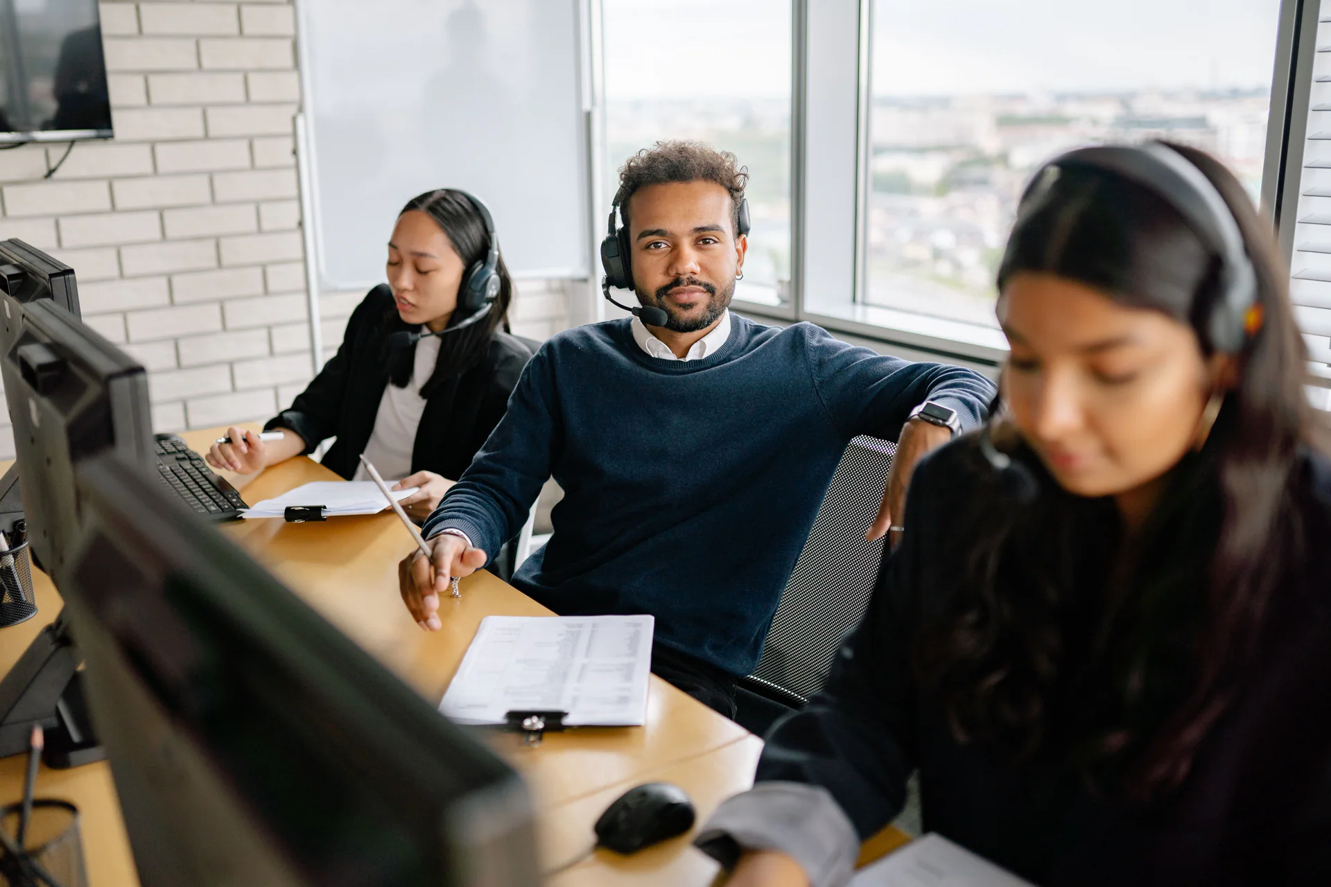 Diverse support team collaborating at desktop workstations