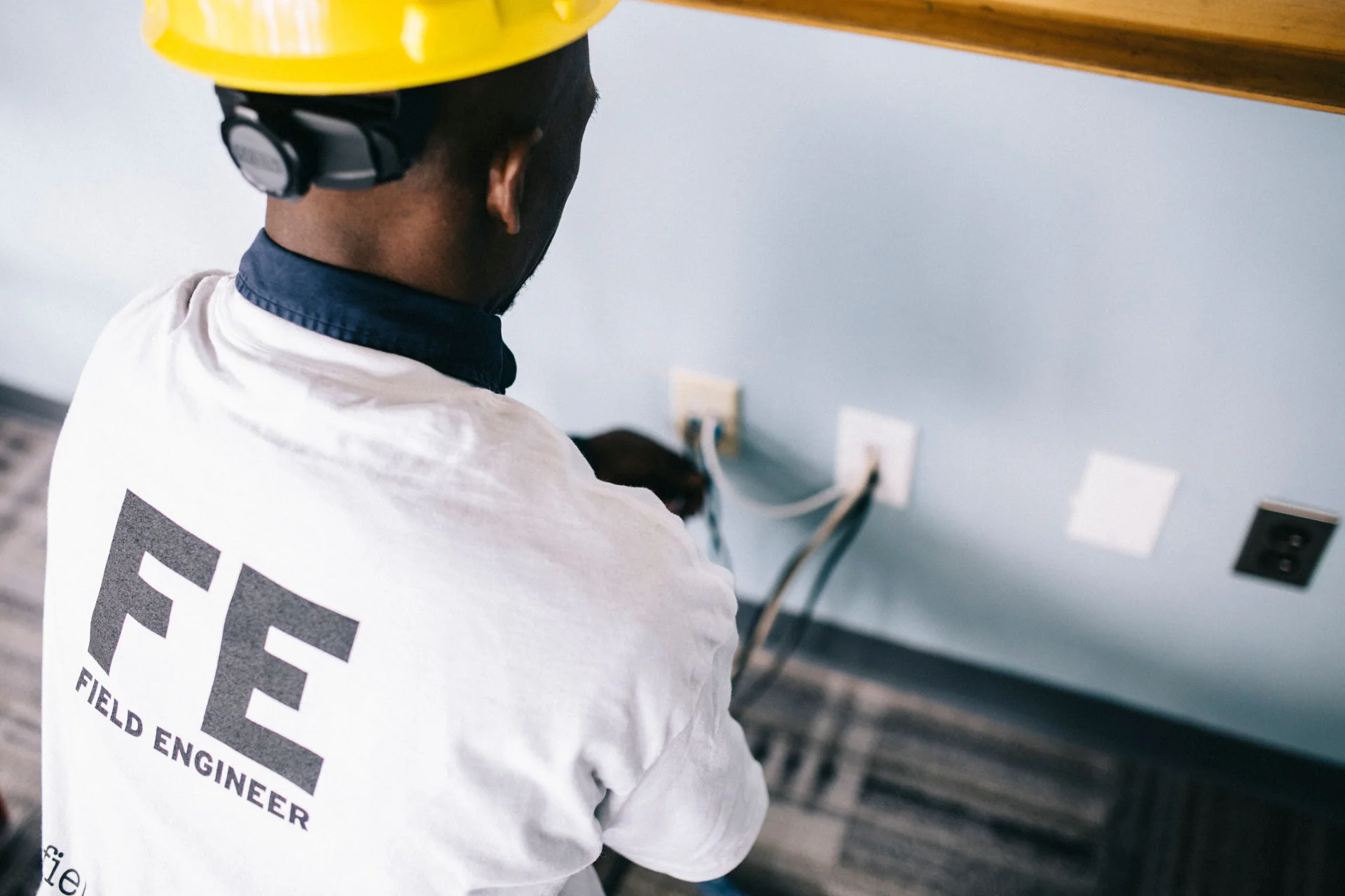 Black field engineer repairing an electrical installation inside a home