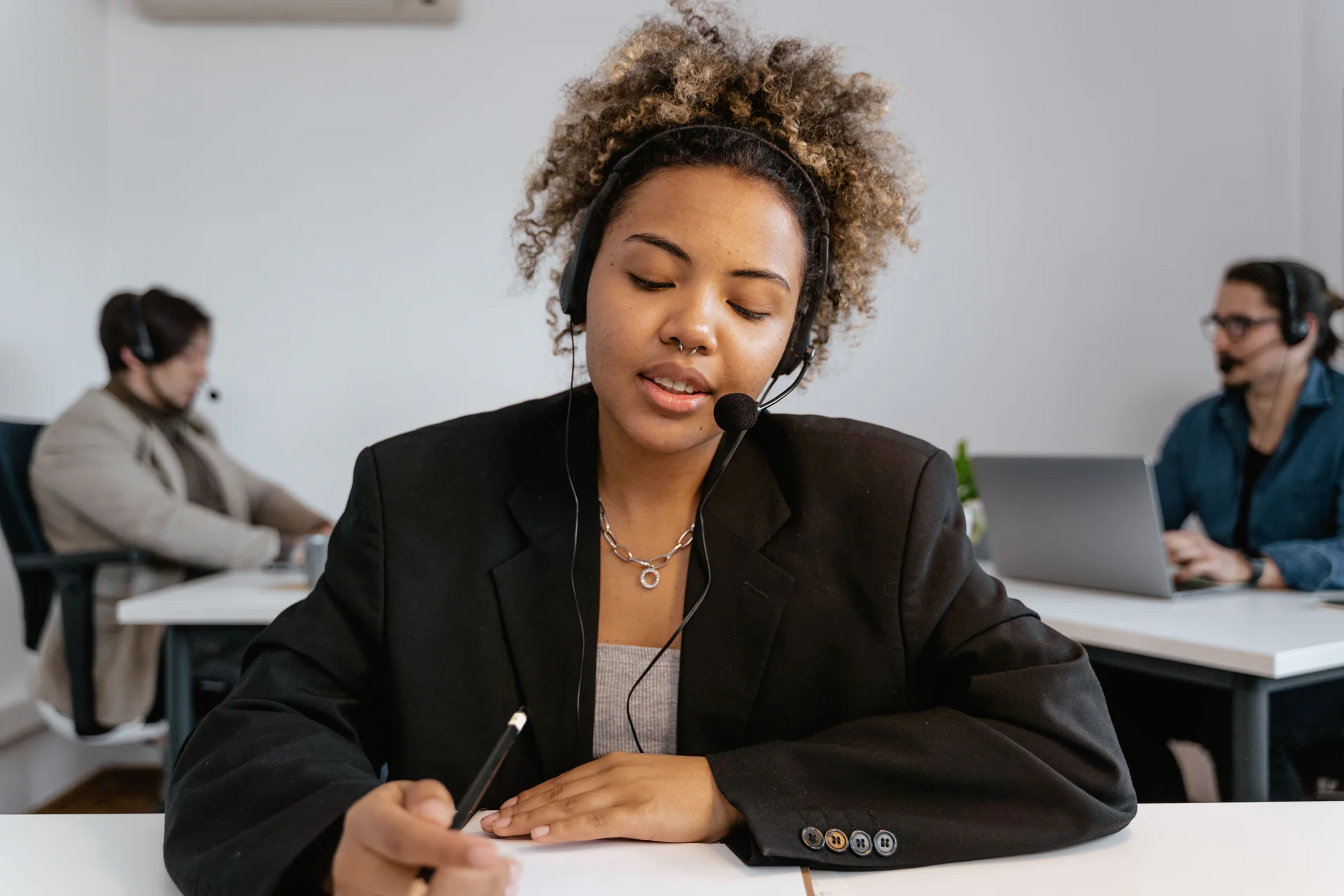 Support agent taking notes during a customer conversation