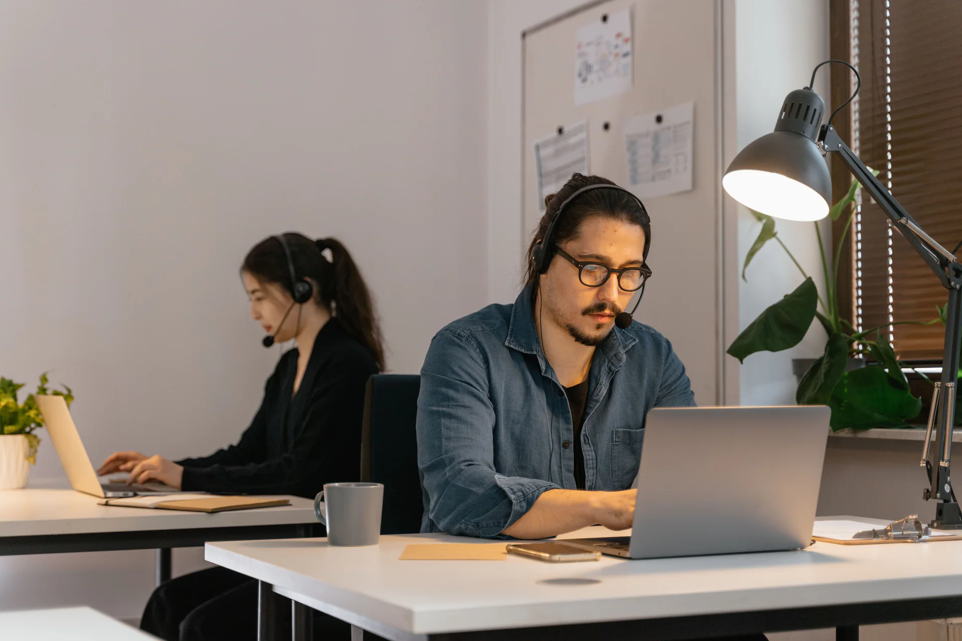 Customer support agent wearing a headset while working on a laptop